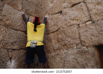 Chitradurga, Karnataka, India - 30 Jan 2022: A selective focus of the famous Indian wall climber named Jyoti Raj, also known as Kothi Raj(Raju or Raja) climbing a rock wall.