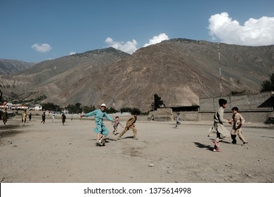 Chitrall, Pakistan - July 28,2018, Local Kids Soccer At Desert Field Over Mountain Backgrund In Nation Of Pakistan