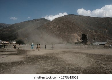 Chitrall, Pakistan - July 28,2018, Local Kids Soccer At Desert Field Over Mountain Backgrund In Nation Of Pakistan