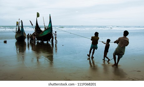 Chittagong, Bangladesh - 06 16 2009: People trying to pull a fishing boat to higher ground