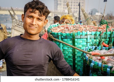 Chittagong, Bangladesh, December 23, 2017: Portrait of a fisherman next to fresh catch of shrimp at the fish market in Chittagong