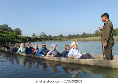 CHITWAN, NEPAL - OCTOBER 20, 2016: Tourists are traveling by wooden boat in Rapti River. 