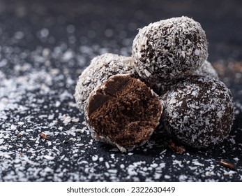 Choco Almond Energy Balls are neatly presented and isolated with a slightly grayish black background.