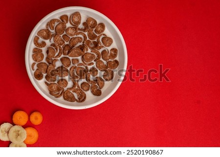 Choco flakes with milk in red background with space