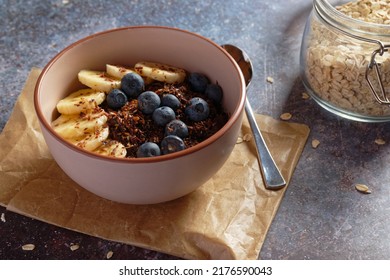 Chocolate banana oatmeal, with ground flaxseed and blueberries - Shutterstock ID 2176590043