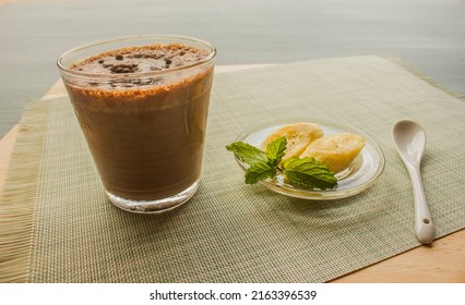 Chocolate Banana Shake Topping Sprinkled With Chocolate Chips Bananas And Mint Leaves And A Spoon Are Placed
