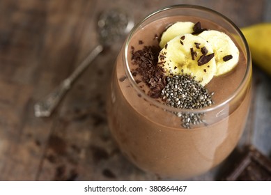 Chocolate banana smoothie with  chia seed on a rustic table.
