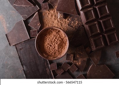  Chocolate bar pieces and  cocoa powder on gray abstract background.  