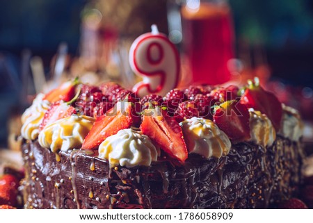 Chocolate birthday cake with candle. 9th birthday cake.