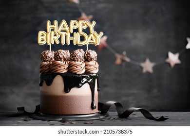 Chocolate birthday cake with  chocolate ganache drip icing and happy birthday banner - Shutterstock ID 2105738375