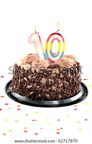 Chocolate birthday cake surrounded by confetti with lit candle for a tenth birthday or anniversary celebration