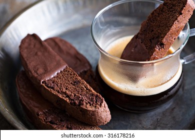 Chocolate biscotti cookies dipped in chocolate with a cup of coffee