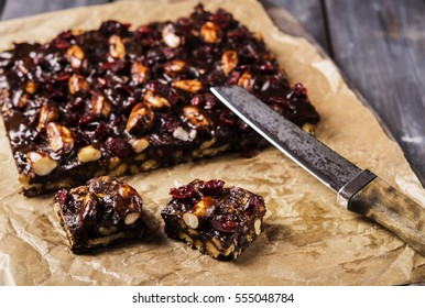 Chocolate And Biscuit Cake With Brazil Nuts And Dried Cranberries Sliced Into Pieces. Selective Focus 