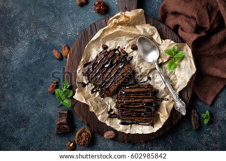 Chocolate brownie cake, dessert with nuts on dark background, directly above