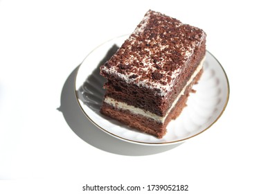 Chocolate brownie cake, dessert with white cream and chocolate topping on a light background