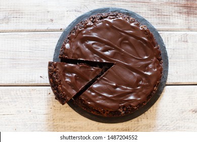 Chocolate brownie cake with ganashe topping on wooden background top view