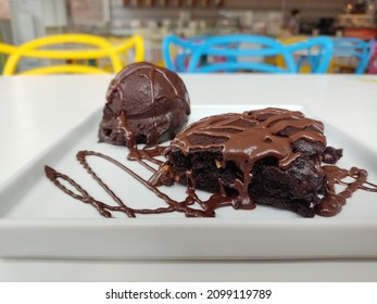 Chocolate Brownie With Ice Cream And Syrup Decorating Served On Plate.