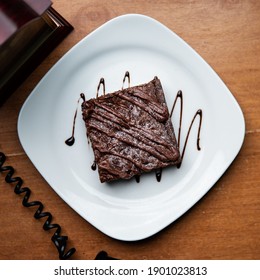 Chocolate Brownie In A White Plate Overhead Shot.