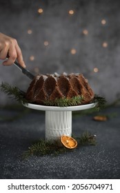 Chocolate Bundt Cake On A White Cakestand, Dry Orange, Holy And Christmas Lights