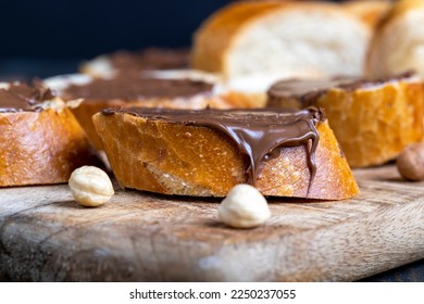 chocolate butter spread on a baguette, sweet chocolate butter spread on a baguette during the preparation of a simple dessert at home - Shutterstock ID 2250237055