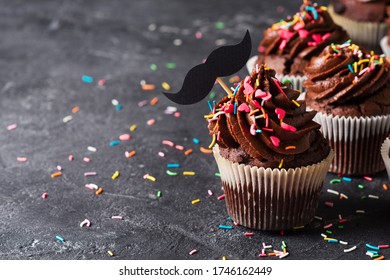 Chocolate Cacao Cupcakes With Moustache And Sprinkles Decor, Fathers Day Concept, Copy Space On Dark Background