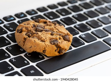 Chocolate cake cookie on keyboard symbol of internet cookies
