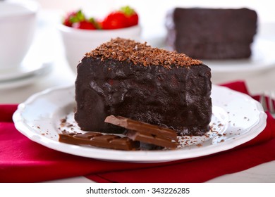 Chocolate cake with chocolate cream and fresh strawberries on plate, on light background - Shutterstock ID 343226285