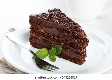 Chocolate cake with chocolate cream on plate, on light background - Shutterstock ID 343228019