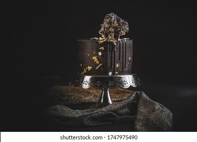 Chocolate Cake With Gold Decoration On Silver Stand