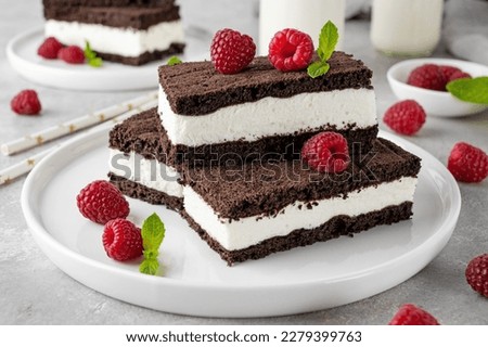 Chocolate cake with milk cream filling on a white plate with fresh raspberries and mint with bottles of milk. Delicious dessert. Copy space