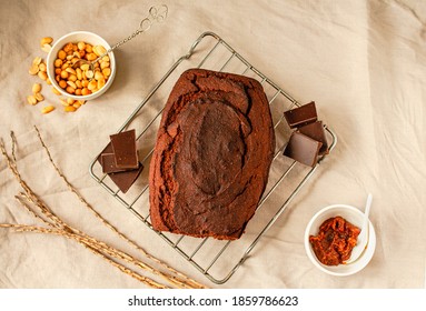 Chocolate Cake With Nuts And Caramel On Wire Rack On A Light Linen Cloth.Holiday Baked Goods Concept