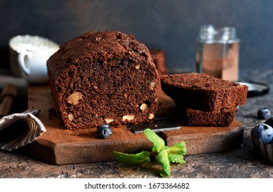 Chocolate cake with nuts and peel on a kitchen table.