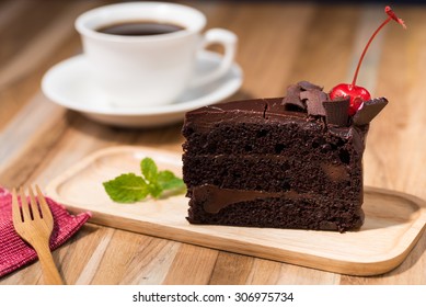 Chocolate Cake On Wooden Table With A Coffee Cup