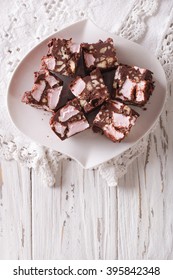 Chocolate Cake Rocky Road With Marshmallow And Nuts Close-up On A Plate On The Table. Vertical View From Above
