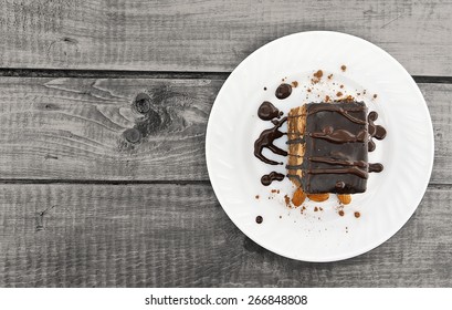 Chocolate Cake Slice With Nut On Plate On Wooden Table, Top View