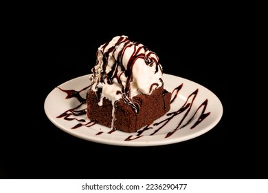 Chocolate cake topped with ice cream on a black background for montage in advertisements.