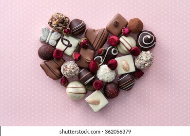 Chocolate Candies And Dried Rose Flowers Heart Shape Composition. Sweet Gift Of Love For St. Valentines Day.