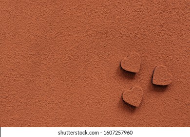 Chocolate candies heart sprinkled with cocoa powder. Abstract background.Valentines day. Cocoa texture. View from above