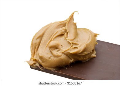 Chocolate Candy Bar Dipped Into Peanut Butter Isolated Over White Background. Clipping Path Included.