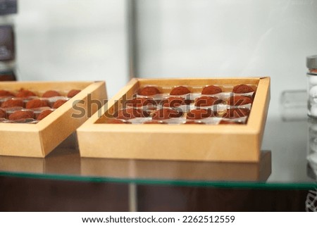 Chocolate candy in a carton box on a shop window of a bakery