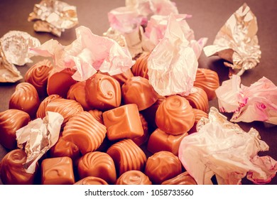 Chocolate Candys Unwrapped, Wrapper On The Candy Open. The Wrapper For The Sweets Is Scattered. The Concept Of Overeating And Diet.