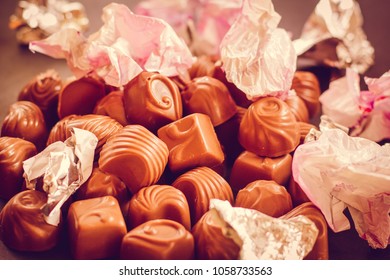 Chocolate Candys Unwrapped, Wrapper On The Candy Open. The Wrapper For The Sweets Is Scattered. The Concept Of Overeating And Diet.