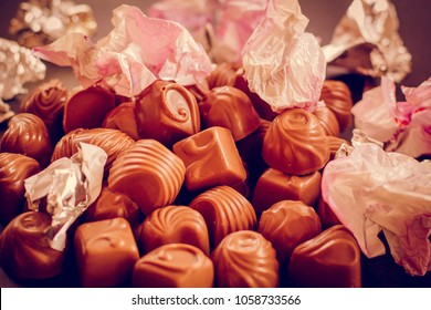 Chocolate Candys Unwrapped, Wrapper On The Candy Open. The Wrapper For The Sweets Is Scattered. The Concept Of Overeating And Diet.