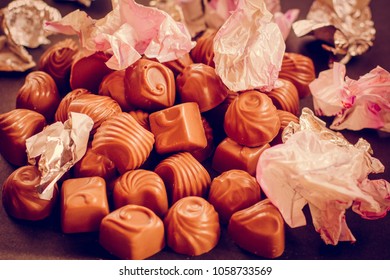 Chocolate Candys Unwrapped, Wrapper On The Candy Open. The Wrapper For The Sweets Is Scattered. The Concept Of Overeating And Diet.