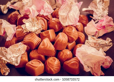 Chocolate Candys Unwrapped, Wrapper On The Candy Open. The Wrapper For The Sweets Is Scattered. The Concept Of Overeating And Diet.