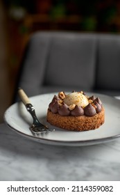 Chocolate Caramel Pie With Nuts In A White Plate On A Marble Background.