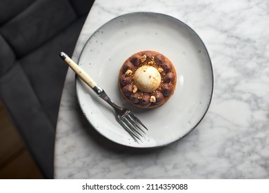 Chocolate Caramel Pie With Nuts In A White Plate On A Marble Background.