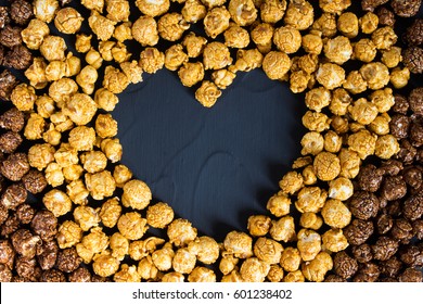 Chocolate caramel popcorn with heart shape. Love popcorn concept. Horizontal photo. Sweet food