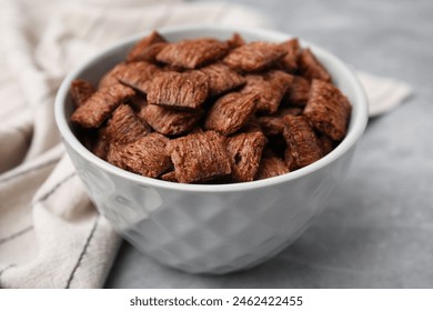 Chocolate cereal pads in bowl on grey table, closeup - Powered by Shutterstock