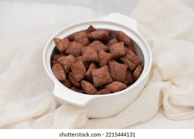 Chocolate Cereals In Small White Bowl On Gray Ceramic